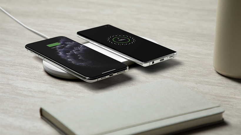 Two smartphones being charged on the BOOSTCHARGE Dual Wireless Charging Pad