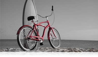 Nikon 1 V3 photo of a bicycle and surfboard on the beach, in selective color